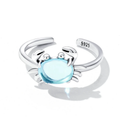 An adjustable sterling silver crab ring with a blue synthetic gemstone in the center, displayed against a white background.